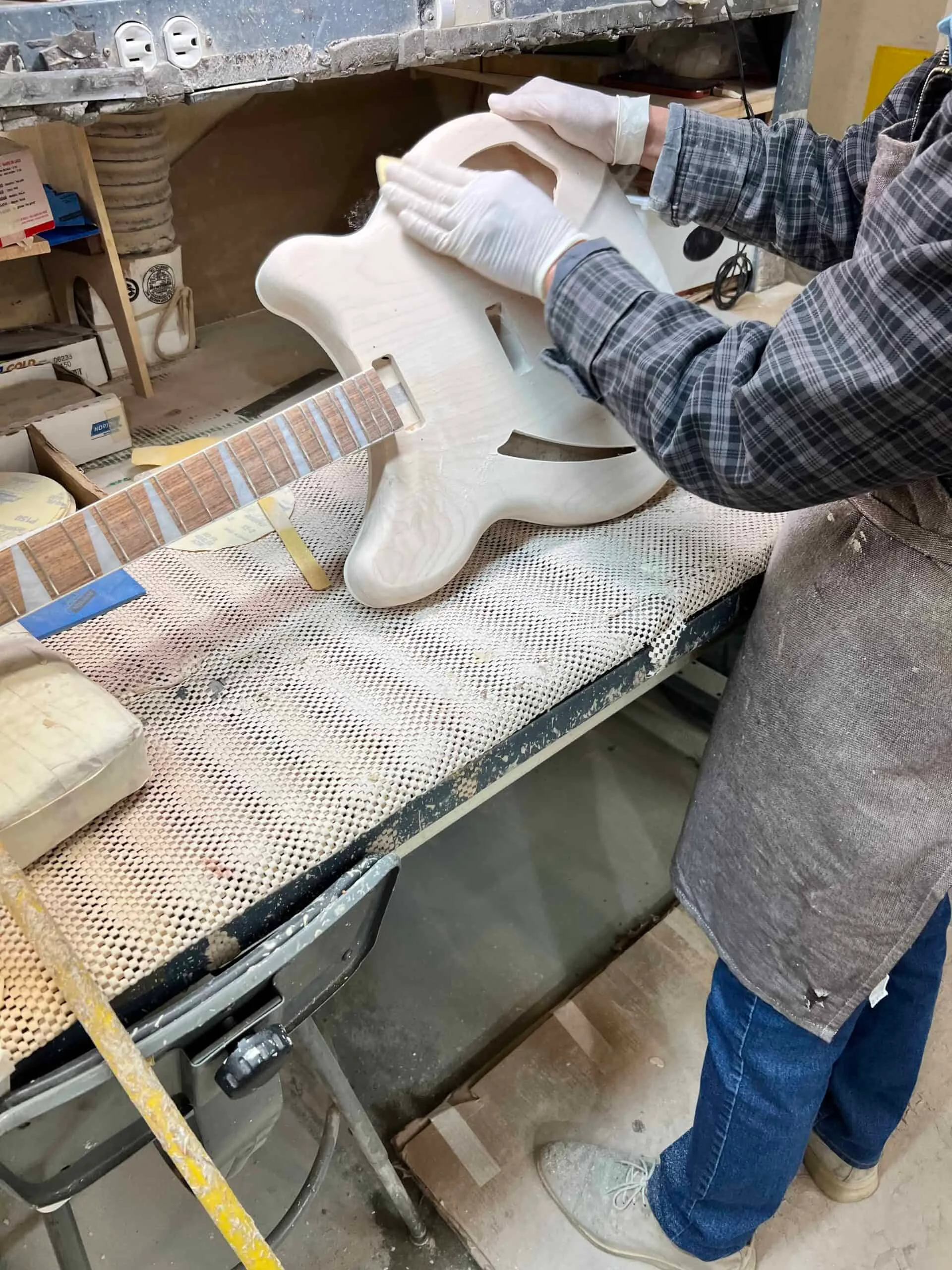 Rickenbacker worker sands body of guitar