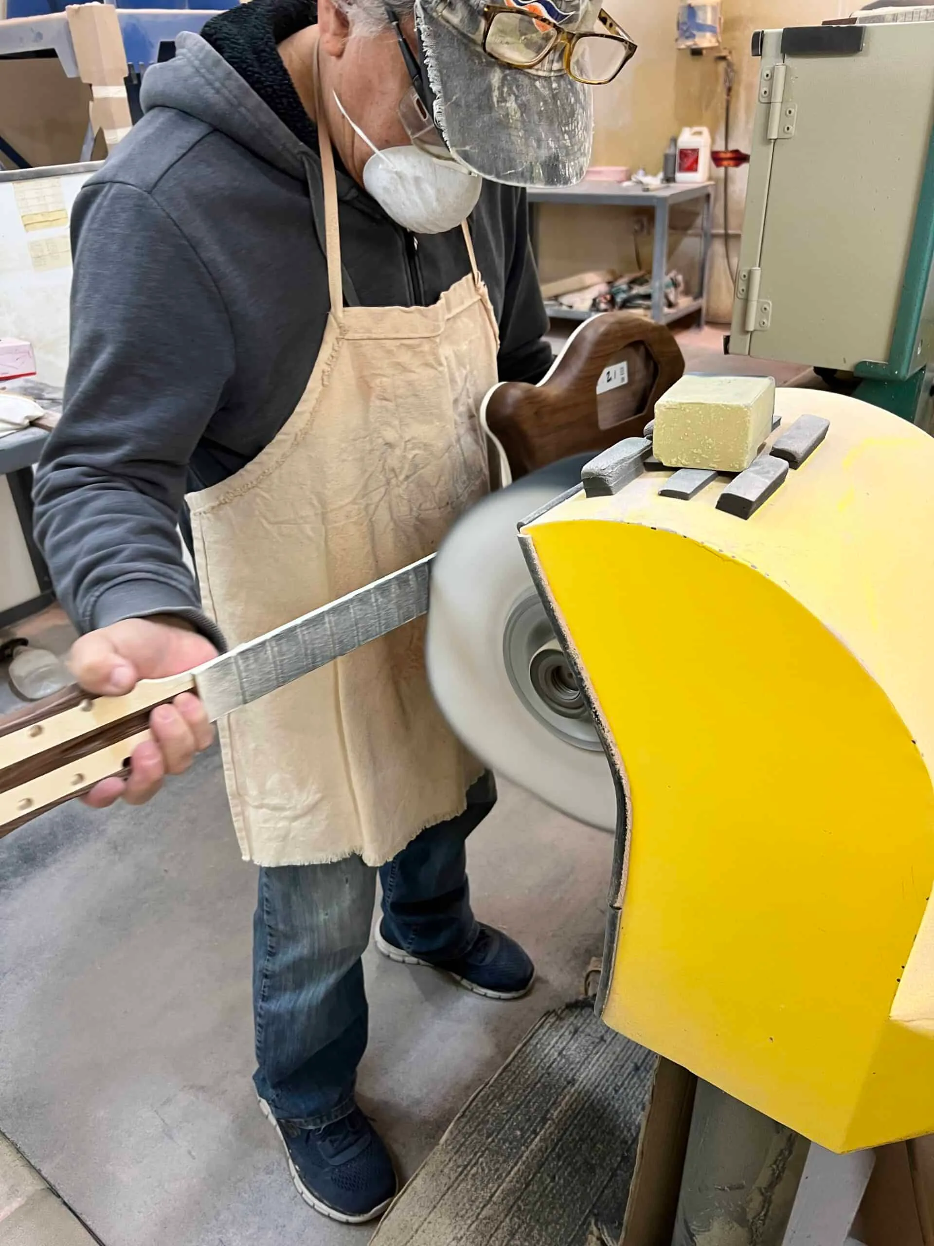 Rickenbacker factory worker polishes a guitar